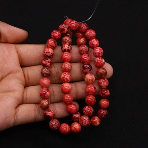 Macro view of red imperial jasper round beads with natural marble texture patterns