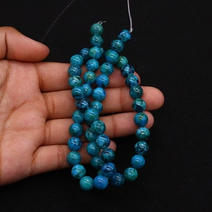 Macro shot of natural turquoise emperorgem round beads with blue-green marbled texture
