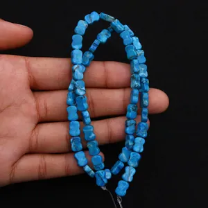 Detailopname van helderblauwe keizerlijke steenkralen in botvorm voor DIY-sieraden maken