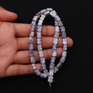 Macro-opname van blauwe botvormige kralen met marmeren textuur voor DIY-sieraden
