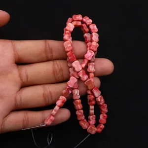 Macro-opname van strikvormige roze marmeren keizersteen kralen voor DIY-sieraden maken