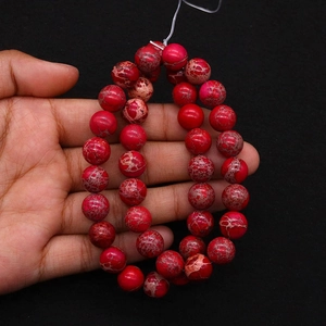 Macro detail of natural emperor stone round beads with red marble textures for DIY jewelry
