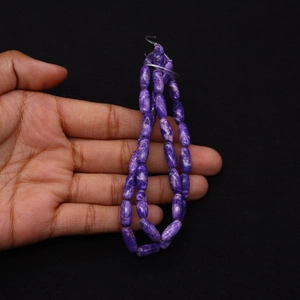 Dettaglio macro di perle a botte in pietra viola naturale per creazione di gioielli