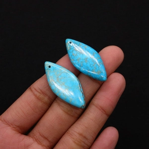 Vue macro de pendentifs en turquoise en forme de losange avec des textures marbrées brunes