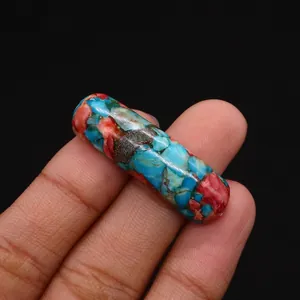 Close-up of polished cylindrical emperor stone beads with colorful mosaic patterns