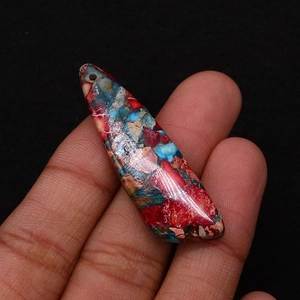 Macro detail of leaf-shaped turquoise pendant with vibrant red and blue marble texture
