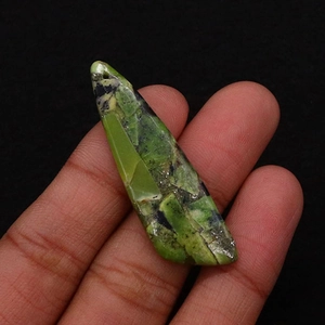 Macro shot of an irregular green emperor stone pendant with black veins and hanging hole