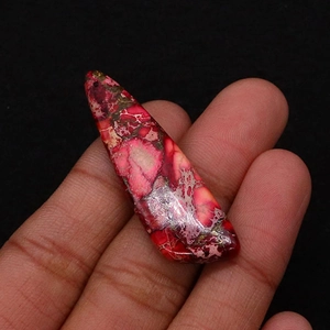 Macro detail of red imperial stone pendant with natural marble textures and polished finish
