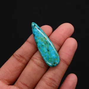 Macro shot of long teardrop turquoise pendant with natural blue-green marbled texture