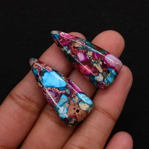 Macro shot of triangle sea sediment jasper stone pendants with vibrant textures and pre-drilled holes