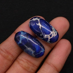 Macro shot of two polished oval blue emperor stone beads for DIY jewelry settings