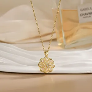 Rotating cat-eye flower pendant necklace with gold chain on white jewelry tray