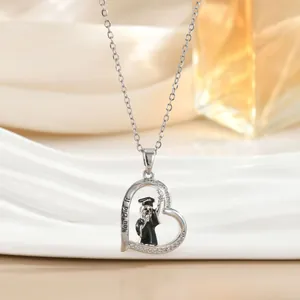 Detail van zilveren hartketting met You Did It gravure en afstudeerhoedje motief voor dames