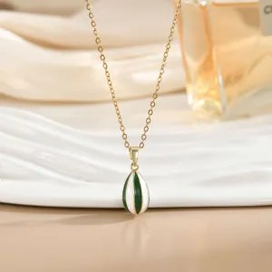 Detalle del colgante de gota dorado con rayas de esmalte en color verde y blanco