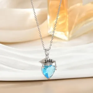 Detailweergave van de 2026 afstudeerhoed hanger met blauw hartkristal aan een zilveren ketting