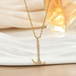 Detailed close-up of a luxury gold hammer pendant necklace with white zircon inlays