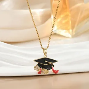 Macro-opname van vergulde afstudeerhoed ketting met rood emaille en kristallen details
