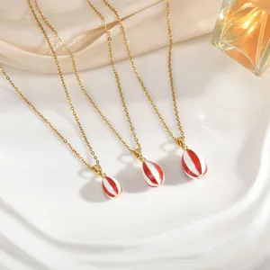 Tres collares con colgante de globo aerostático dorado con esmalte de rayas rojas y blancas