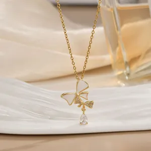 Detail einer goldenen Schmetterlingskette mit weißen Emaille-Flügeln und Zirkon-Anhänger