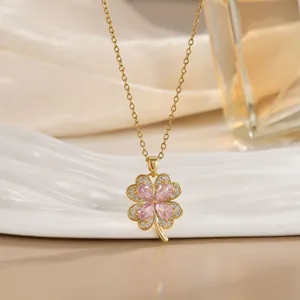 Detailaufnahme der rosa Zirkonia-Kleeblatt-Kette auf edler Champagner-Seide und Goldkette