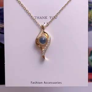 Macro detail of gold necklace with a projection stone and zircon pave accents