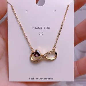 Close-up of titanium gold necklace with infinity pendant and purple heart gemstone