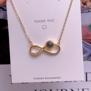 Nahaufnahme der goldenen Unendlichkeit-Kette mit Diamanten und schwarzem Projektionsstein
