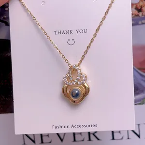 Detailansicht der goldenen Projektionskette mit Kristallen und blauem Stein-Anhänger