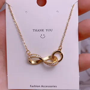 Detailed macro view of the gold infinity pendant with white sparkling zircon stones