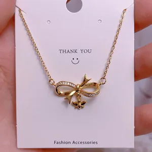 Titanium steel gold necklace featuring a bow and bee pendant with sparkling cubic zirconia