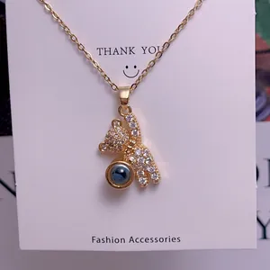 Detailed shot of a gold bear pendant necklace with zircon and 100 languages projection stone