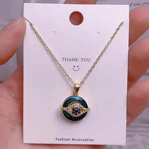 Detailaufnahme einer goldfarbenen Evil Eye Halskette mit grünem Emaille und Kristallen