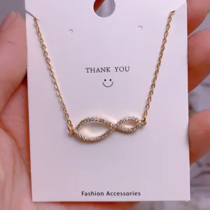 Close-up of gold infinity pendant with pavé cubic zirconia on titanium steel chain
