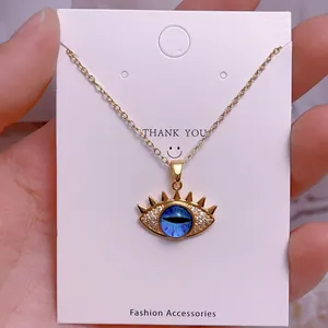 Nahaufnahme der goldenen Evil Eye Halskette mit blauem Zentrum und Sternendetails