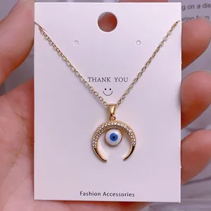 Detailansicht der goldenen Evil-Eye-Halskette mit Mondsichel-Anhänger auf Karte