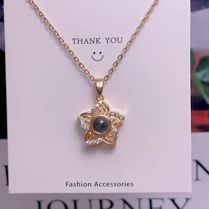 Detailed macro view of a gold flower pendant necklace with 100 languages projection stone