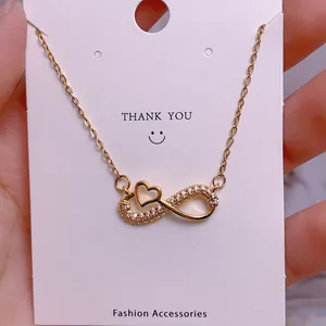 Macro shot of gold infinity heart pendant necklace with shimmering cubic zirconia