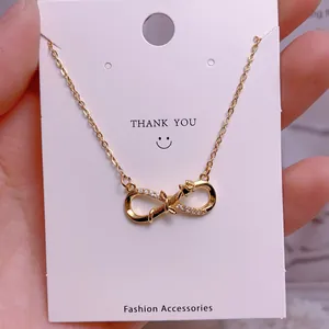 Detail of infinity pendant necklace in gold finish with sparkling pavé crystals