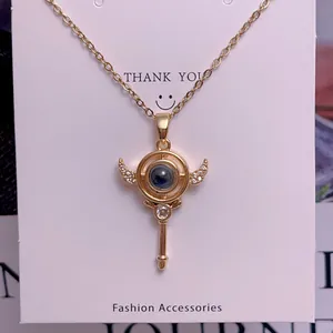 Macro shot of gold key pendant with crystal wings and projection stone on necklace