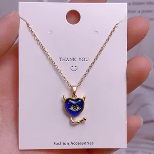 Detailansicht der goldenen Teufelsauge-Herz-Halskette auf weißer Schmuck-Displaykarte