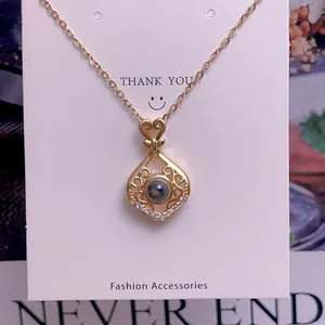 Detail of gold heart pendant necklace featuring micro-projection stone and crystal accents