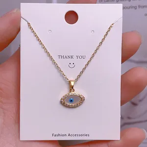Makroaufnahme des goldenen Evil Eye Anhängers mit blauem Emaille und Kristalldetails