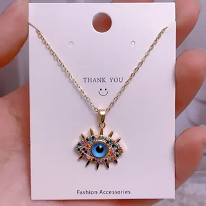 Nahaufnahme der goldenen Evil-Eye-Halskette mit bunten Strasssteinen und blauem Auge
