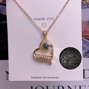 Golden heart-shaped projection necklace with Mom lettering and 100 languages text