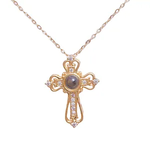 Cross projection necklace in gold finish featuring a central gem and white zircon stones