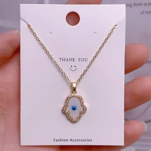 Hamsa-Hand-Halskette mit Evil Eye Anhänger auf einer weißen Geschenkkarte