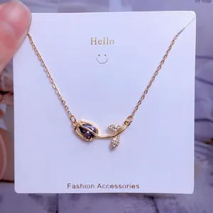Détail d'un pendentif tulipe avec cristal violet en forme de goutte et finition dorée