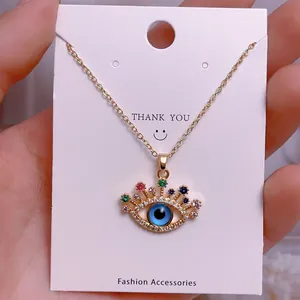 Detaillierte Makroansicht des goldenen Evil Eye Anhängers mit bunten Kristallen und blauem Stein