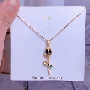 Détail macro du pendentif tulipe avec pétales mats bleus et tige en alliage doré