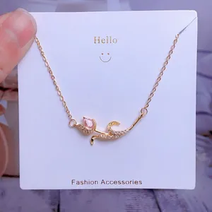 Détail macro du pendentif tulipe avec pierre rose et zircons sur chaîne dorée